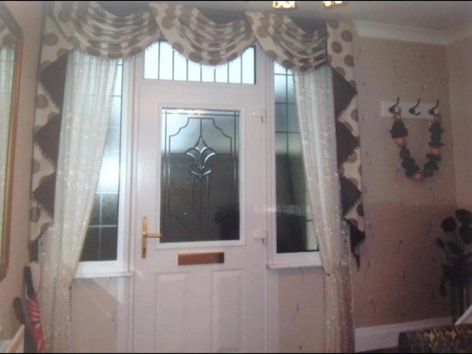 Sheer voile curtains and a swagged valance framing a front door and its side window